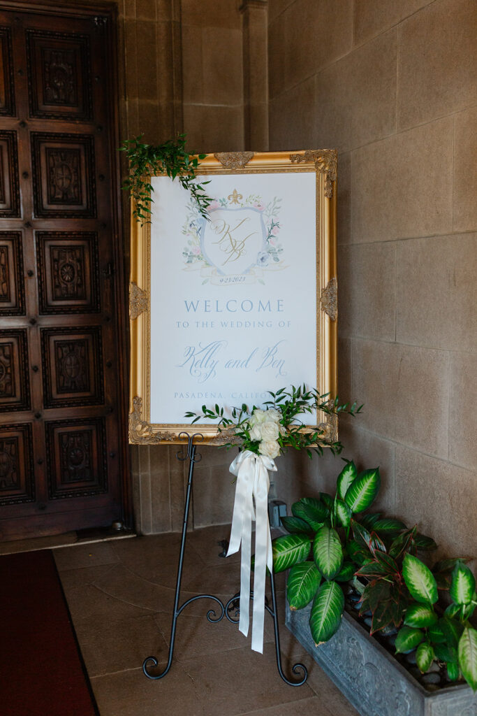 Ben and Kelly’s welcome sign with white flowers beside the doorway.
