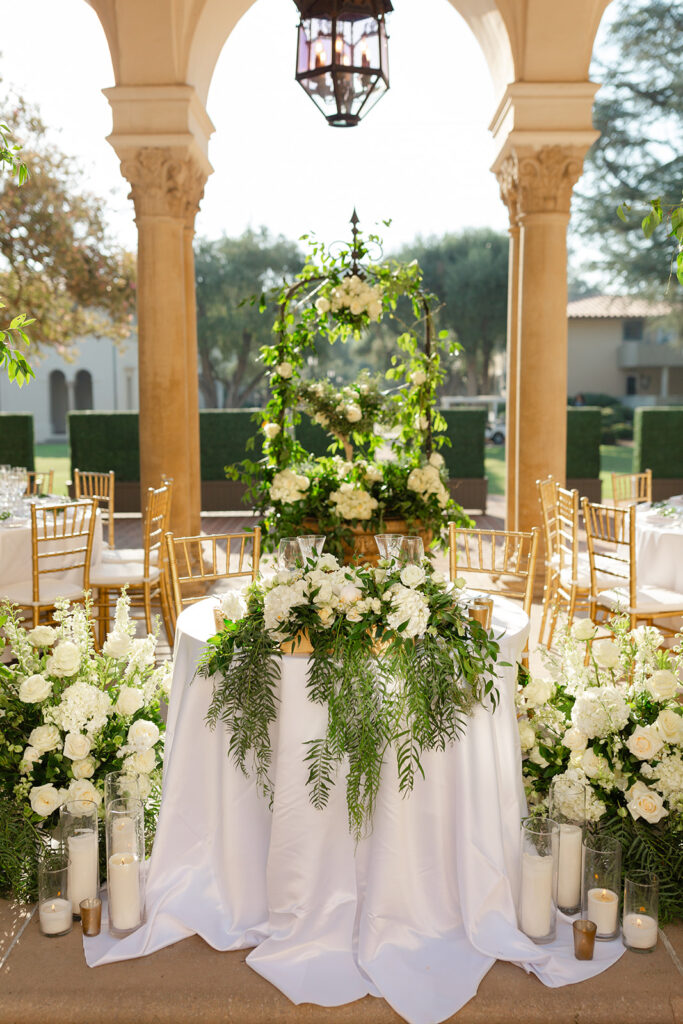 White floral arrangements and candleholders at the outdoor wedding reception.