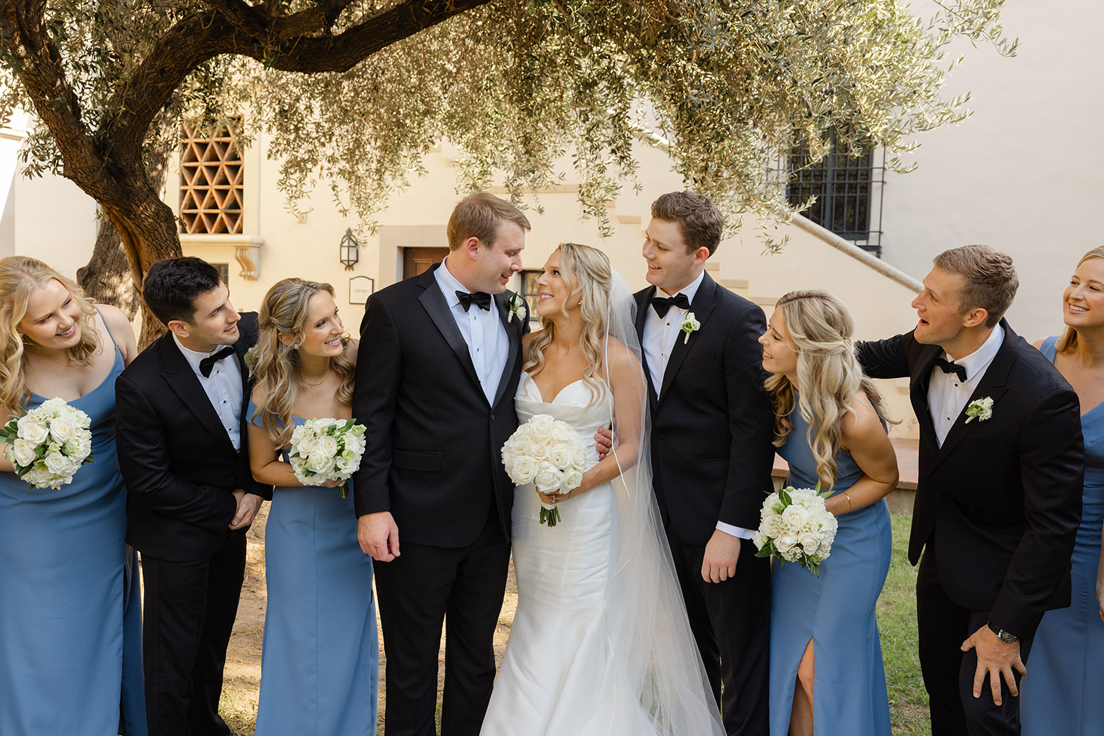 Ben and Kelly standing with their wedding party outdoors.