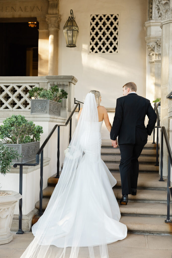 Ben and Kelly walking up the steps together after their church ceremony.