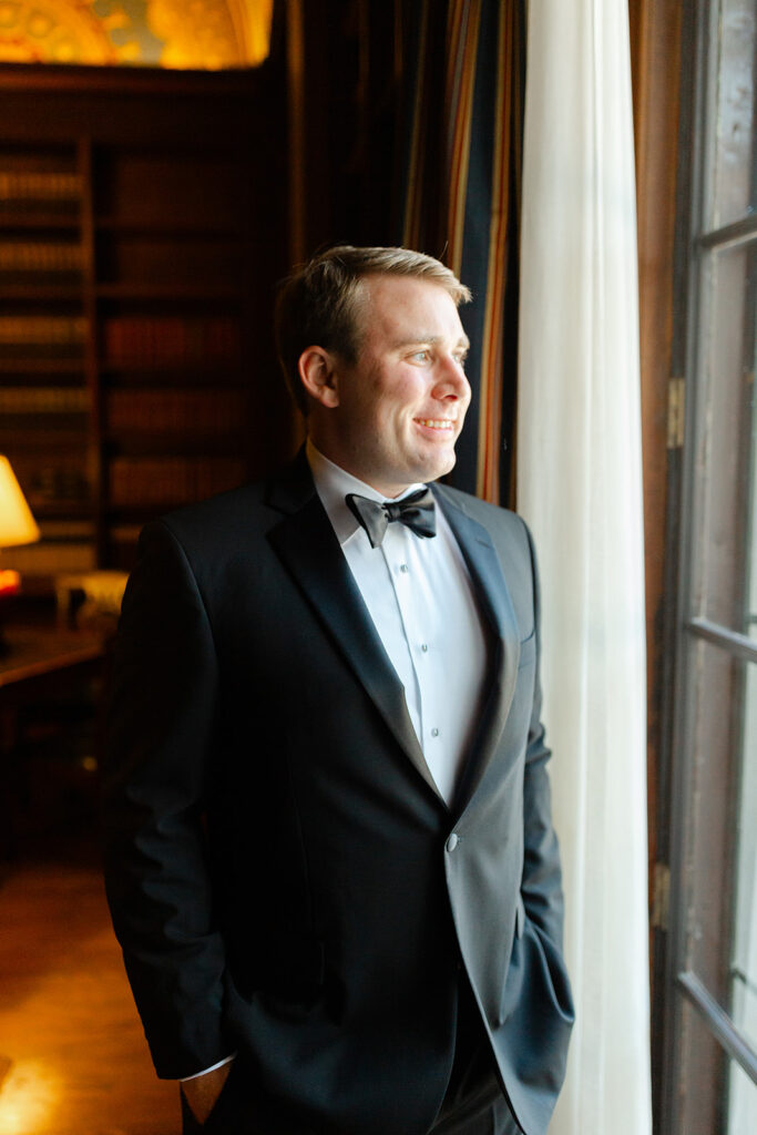 Ben looking through a window in his tuxedo.