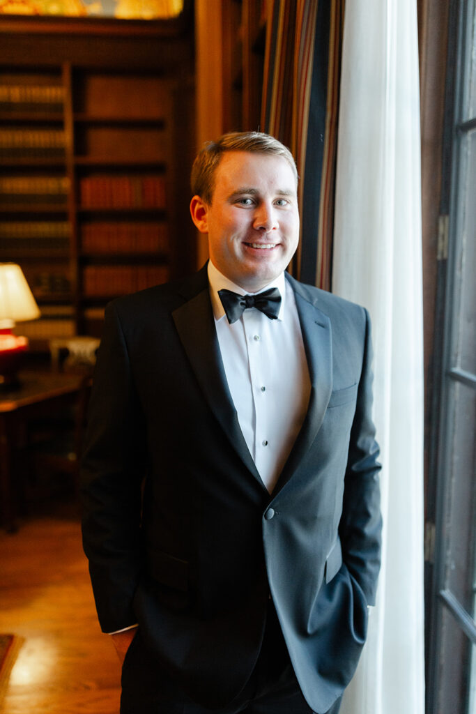 Ben smiling in a dark-paneled room before the wedding ceremony.