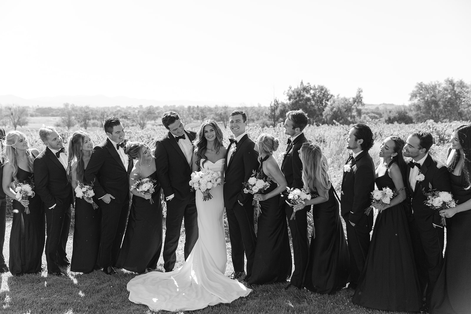 Jake, Zoe, and their wedding party together in black-and-white photography.