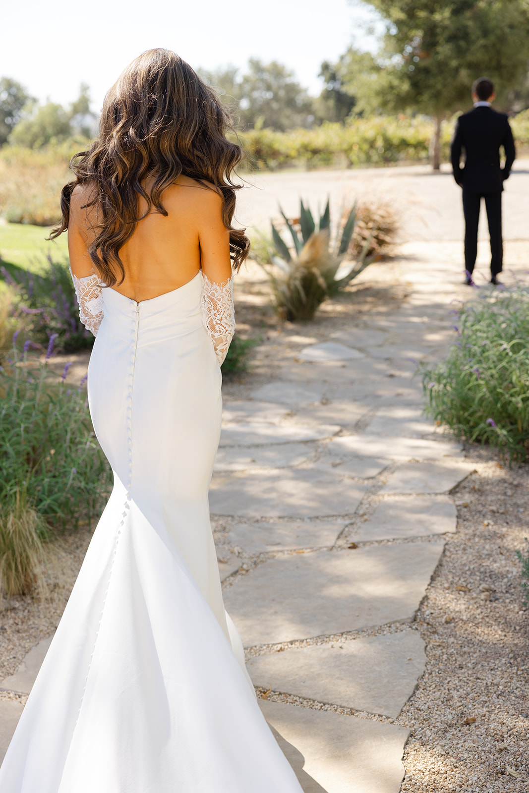 Zoe walking toward Jake along a sunlit garden path.