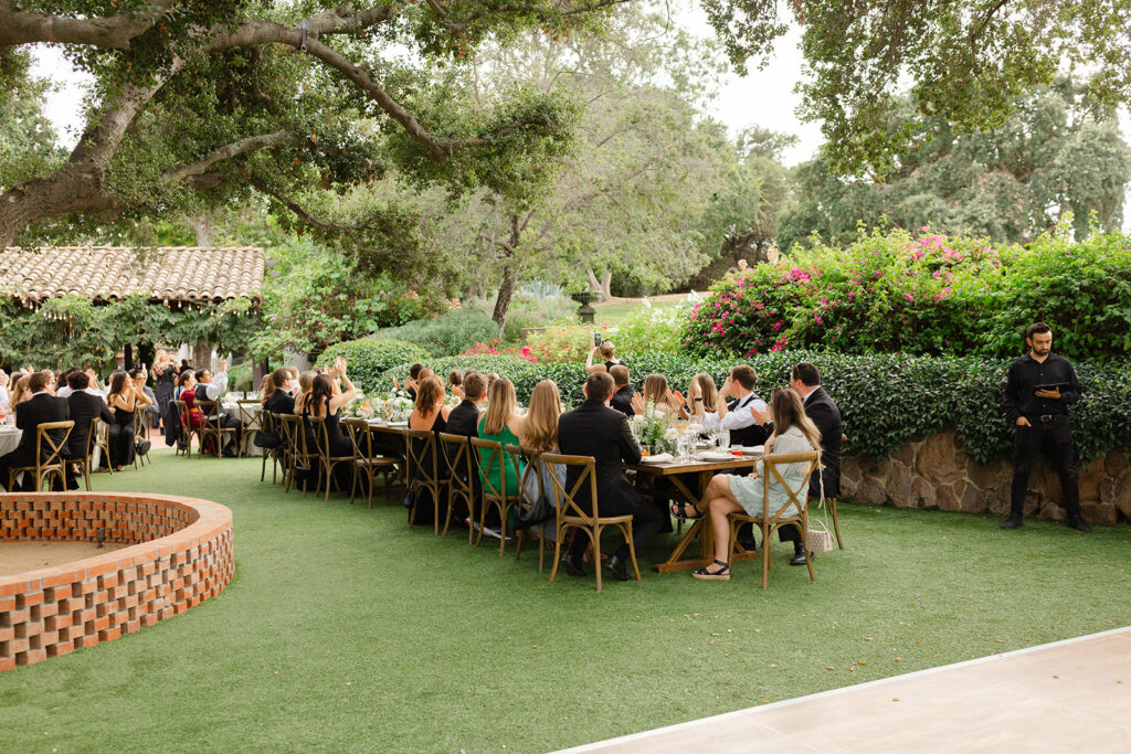 Wedding guests dining outdoors in the gardens at Quail Ranch.