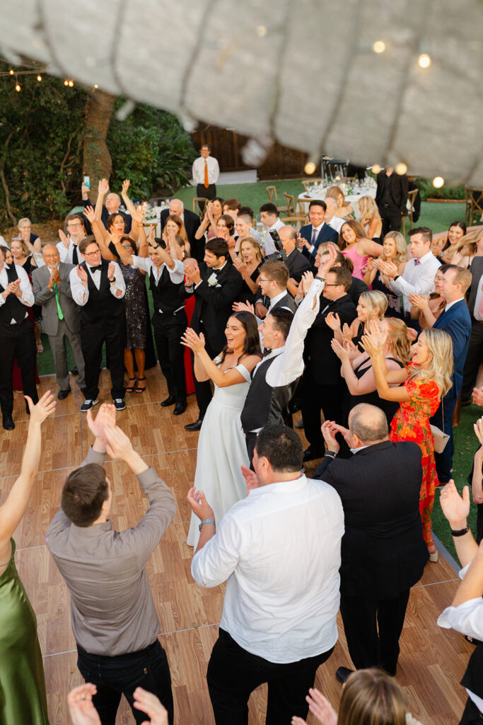 Samantha and Andrew celebrating with guests gathered on the outdoor dance floor.
