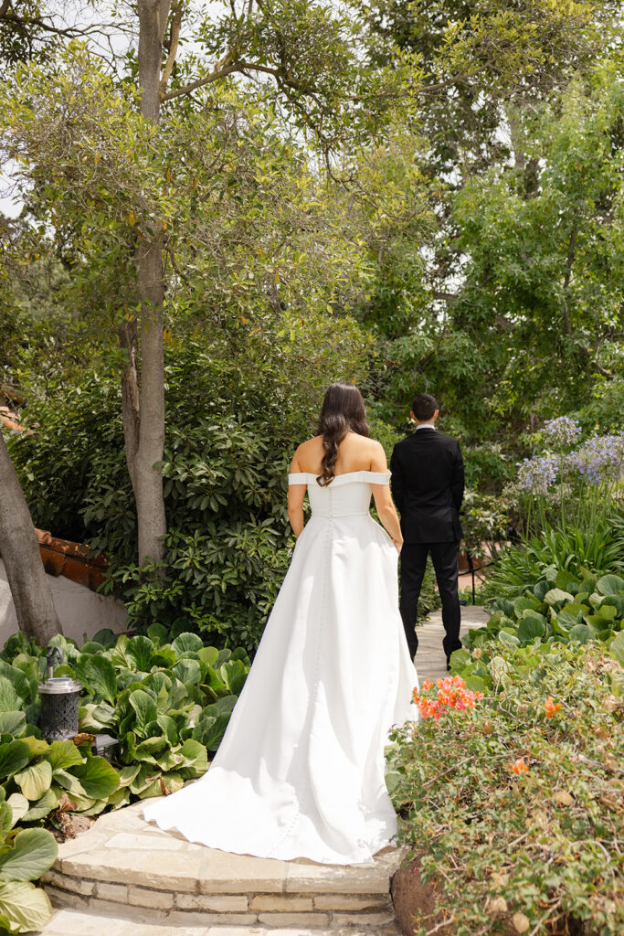 Andrew embracing Samantha on a garden path after their first look.