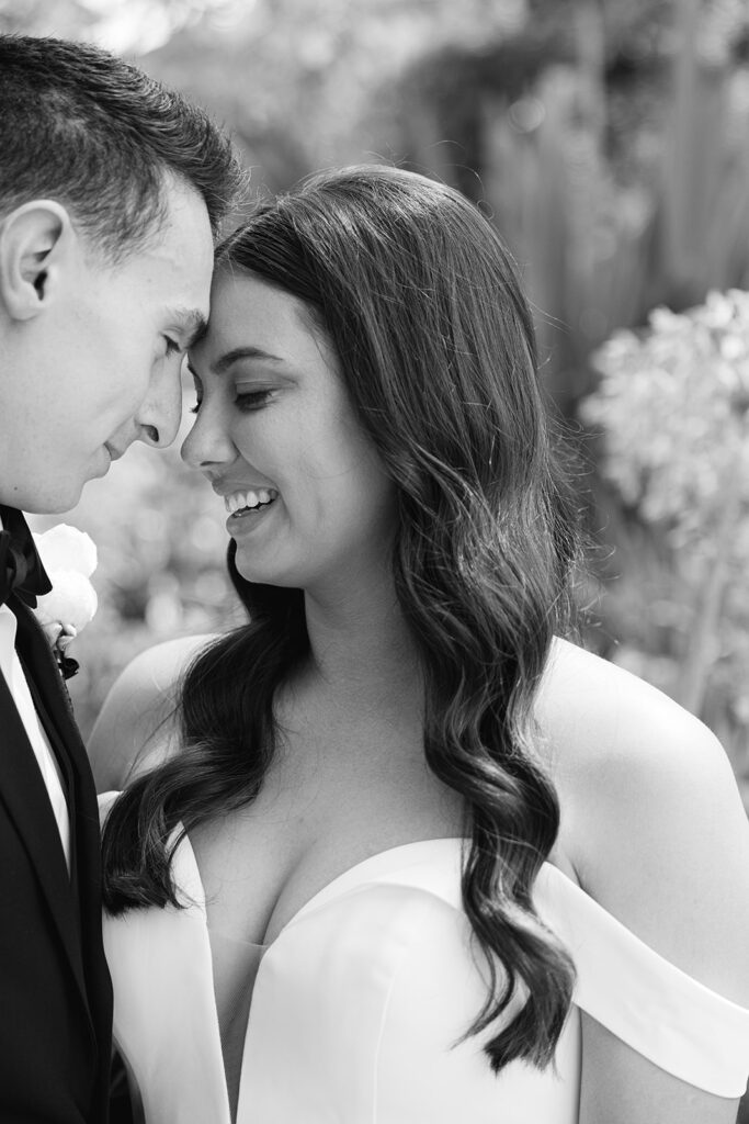 Black-and-white close-up of Samantha and Andrew touching foreheads.