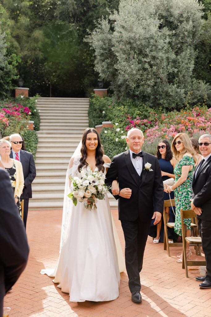Samantha walking down the brick ceremony aisle with her escort.