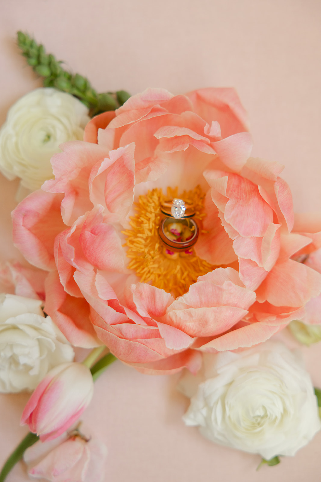 Wedding rings nestled in a peach flower