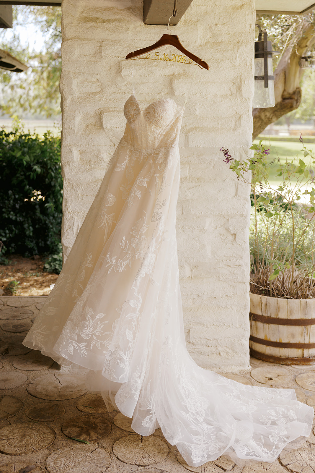 Wedding gown hanging beside a stone pillar