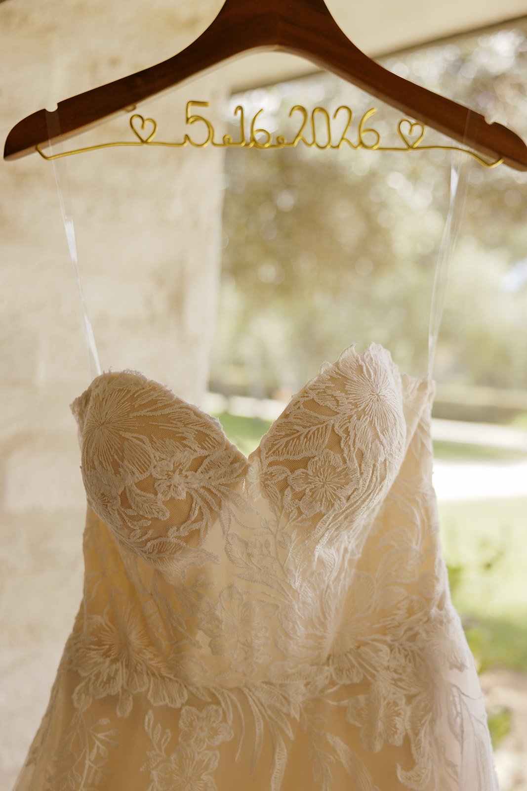 Rachel’s lace gown displayed on a personalized wedding hanger