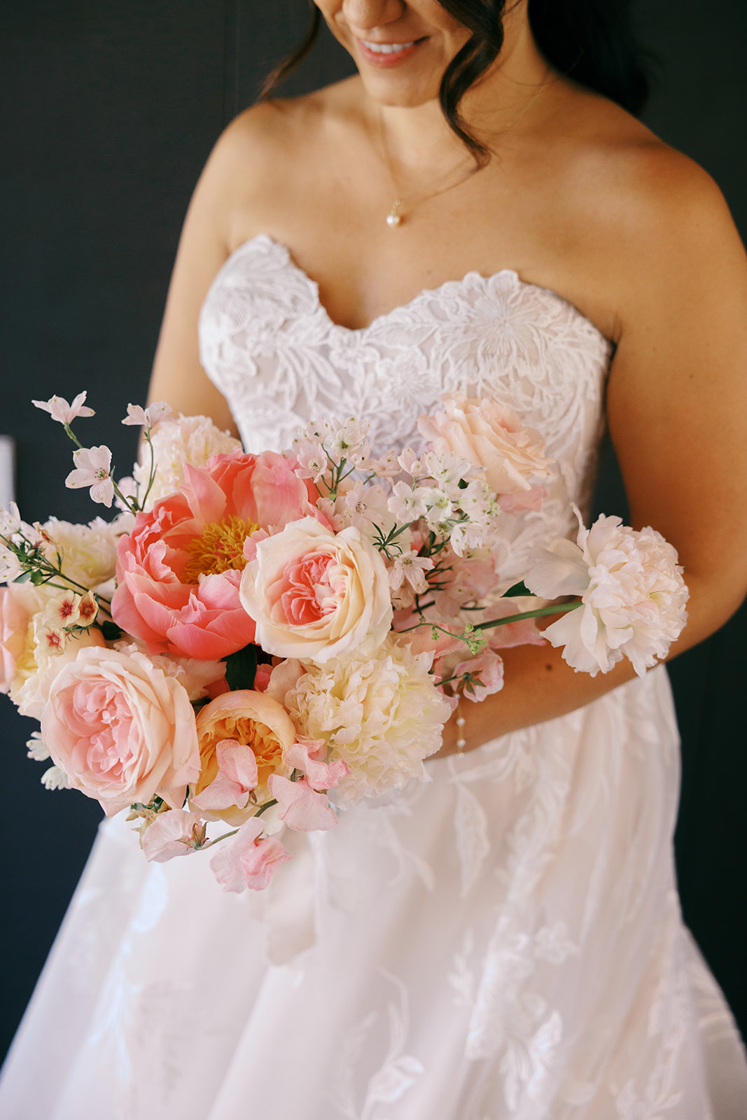 Rachel holding her peach and pink bridal bouquet