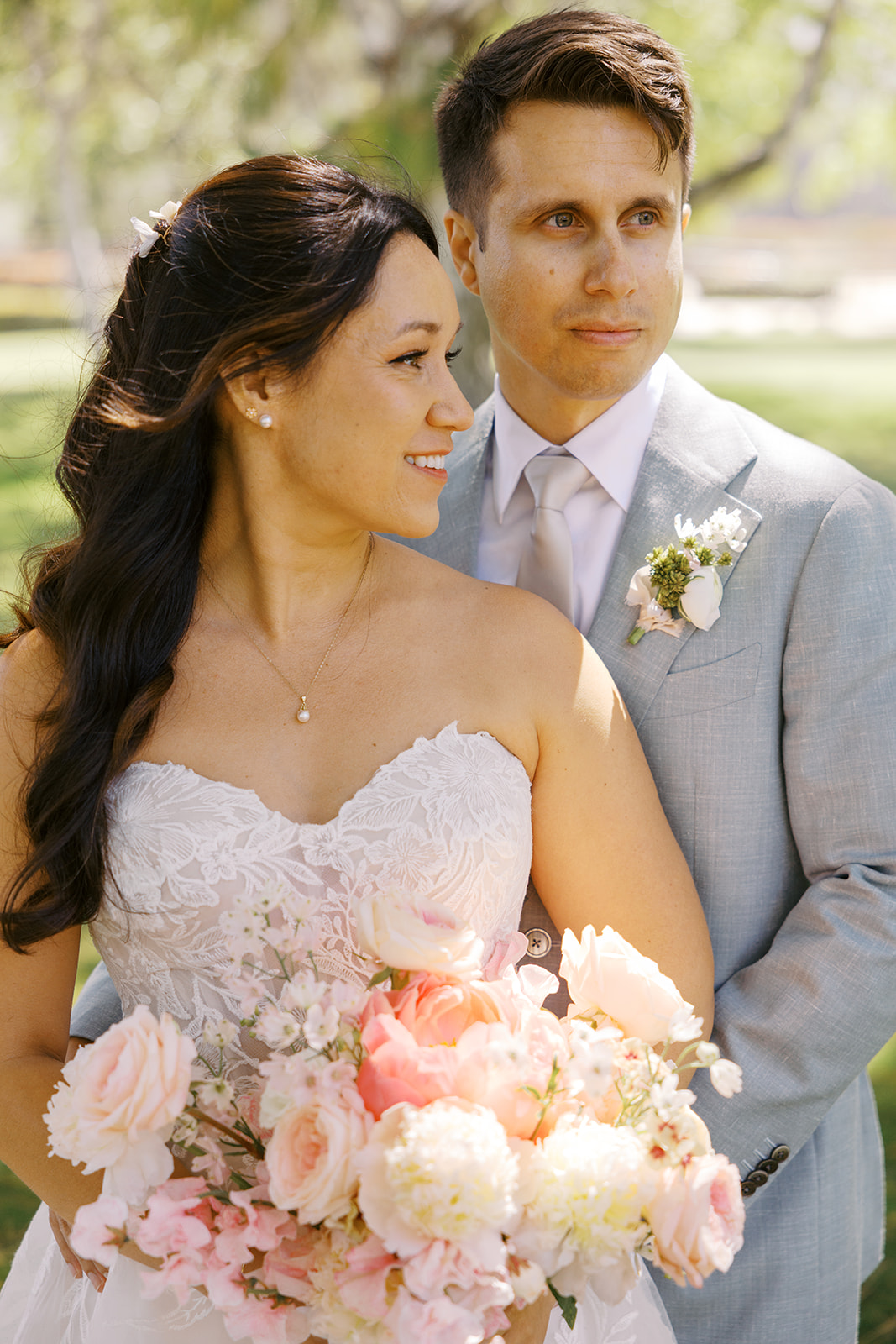 Close portrait of Rachel and Damien with their bouquet