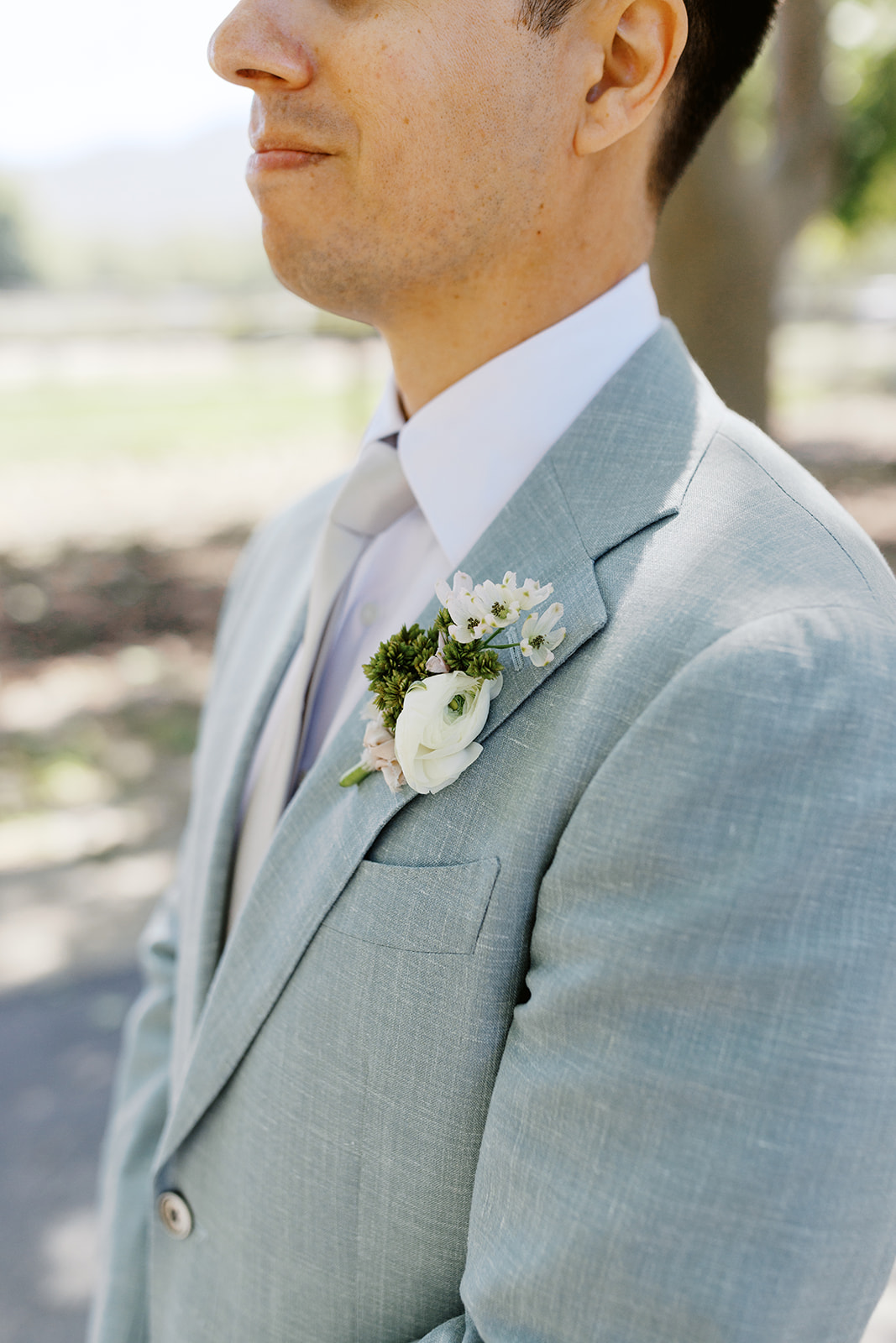 White floral boutonniere on Damien’s pale blue suit