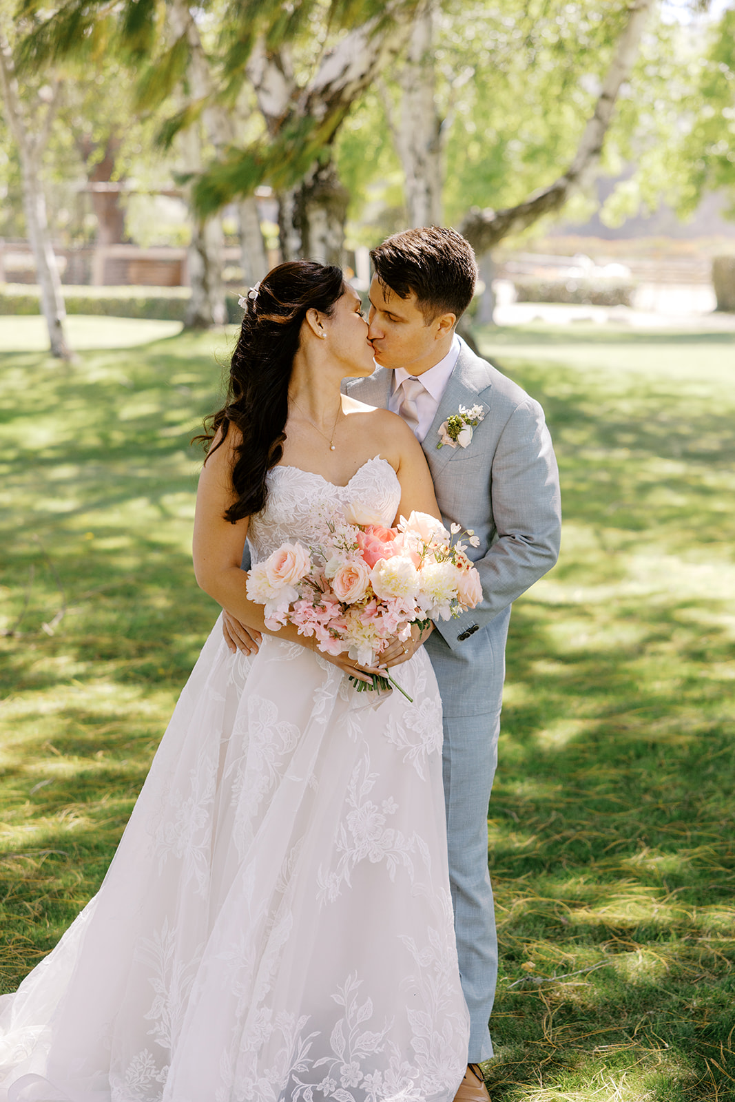 Rachel and Damien kissing beneath the trees