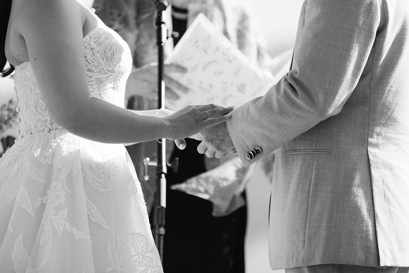 Black-and-white detail of the couple’s hands during their vows