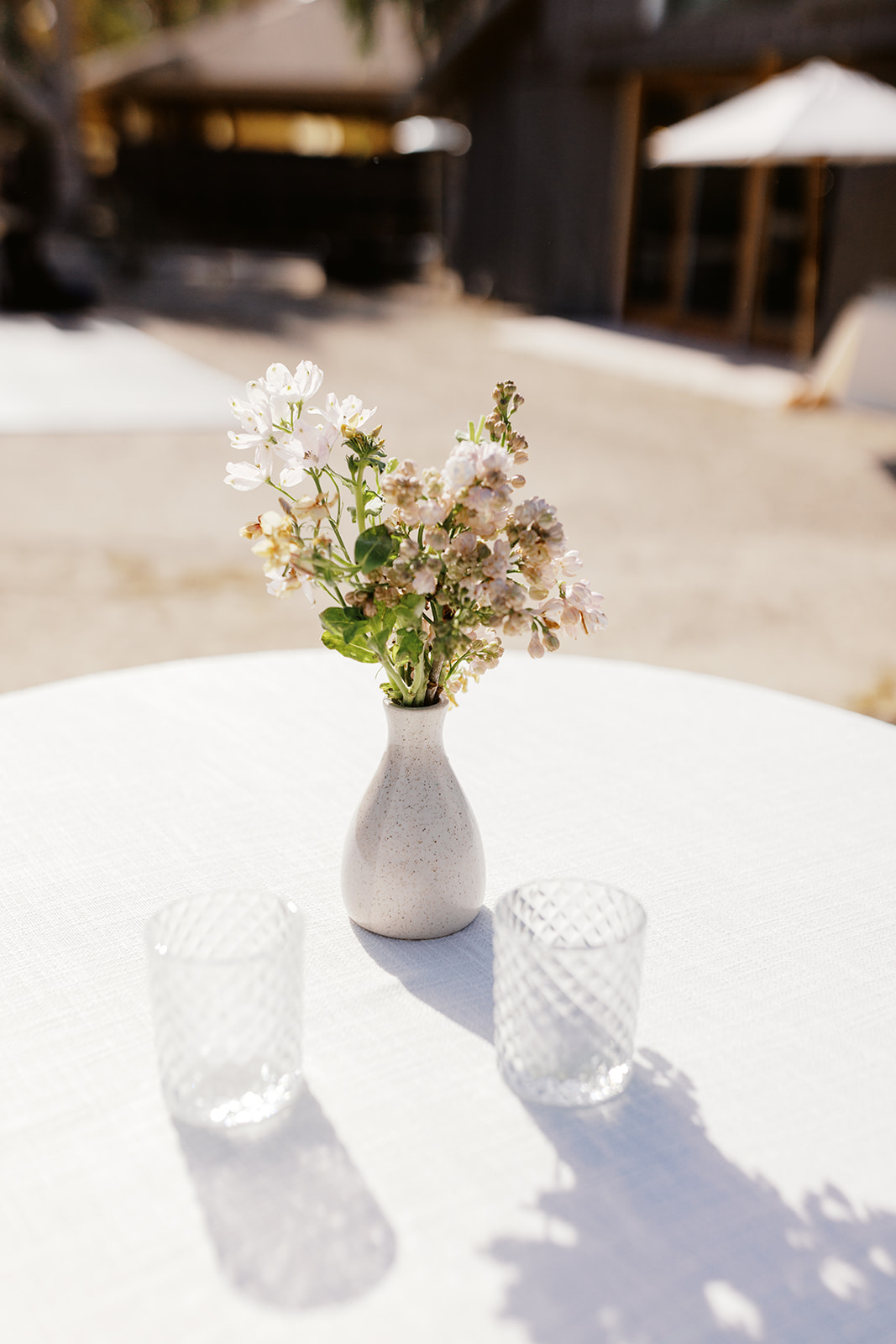 Small floral arrangement and glass votives on a cocktail table