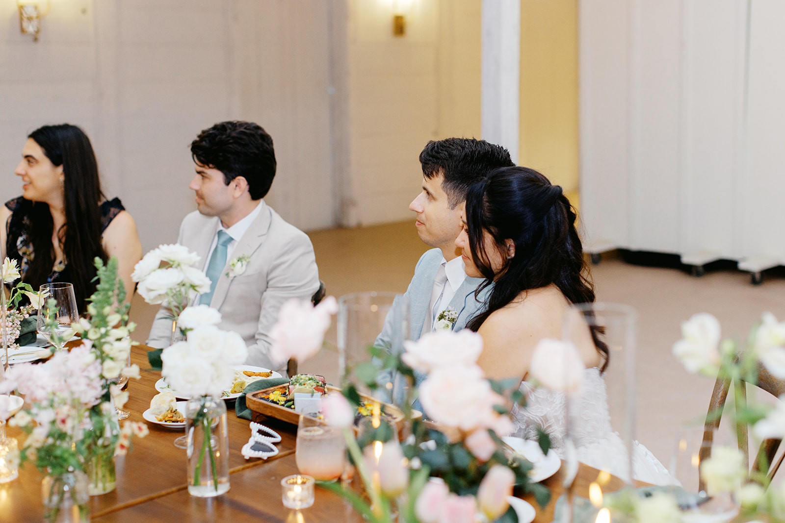Rachel and Damien seated together during reception speeches