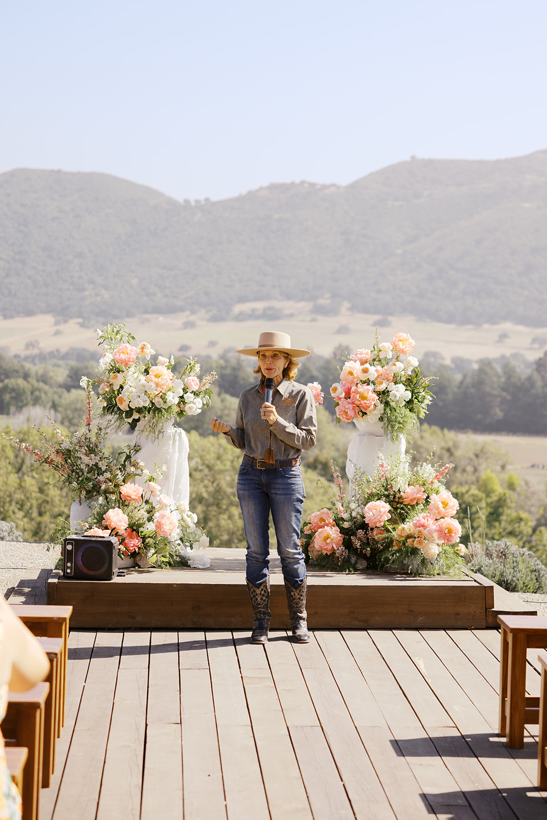 The ceremony setting framed by spring flowers and rolling hills