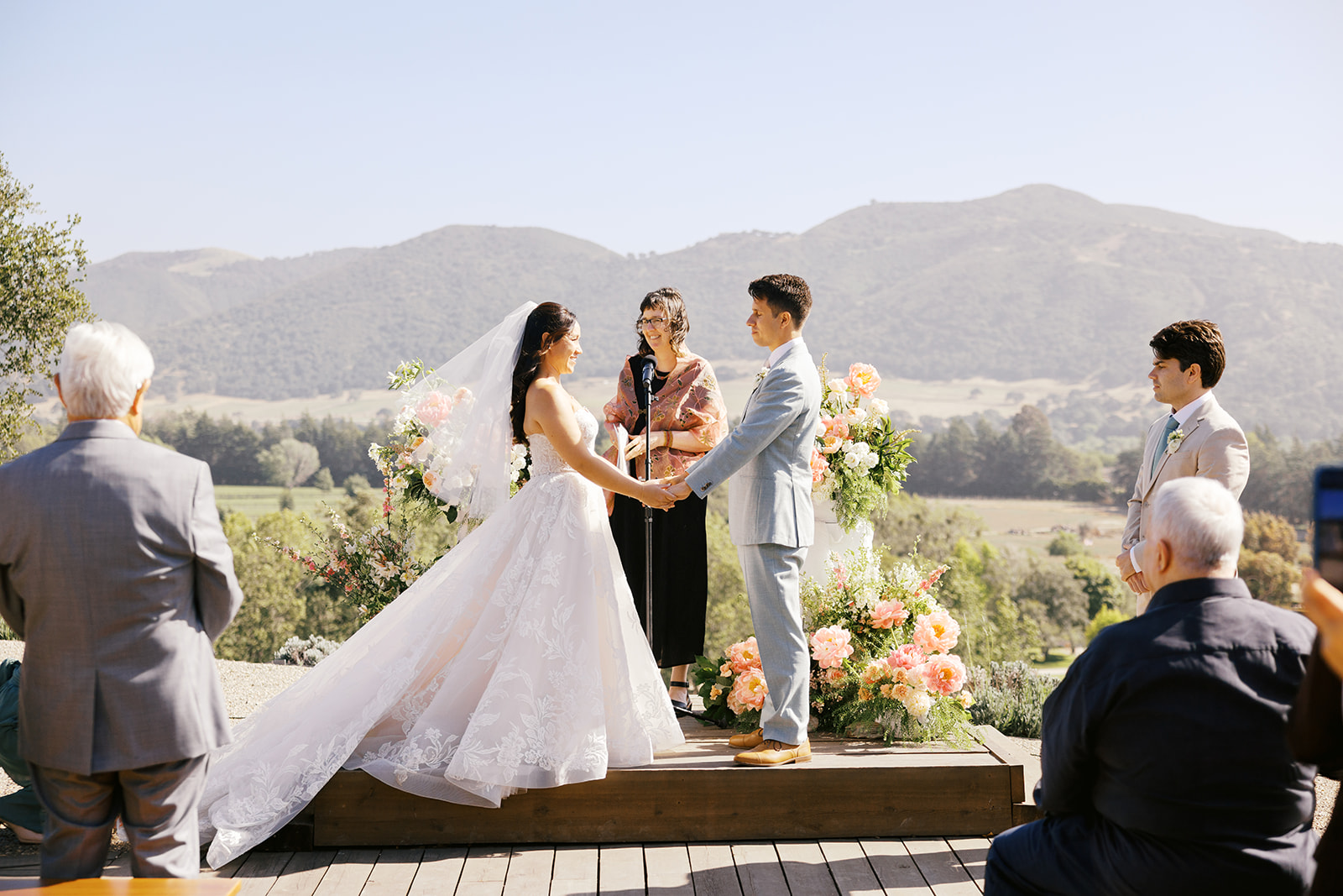 Rachel and Damien holding hands at the hillside ceremony