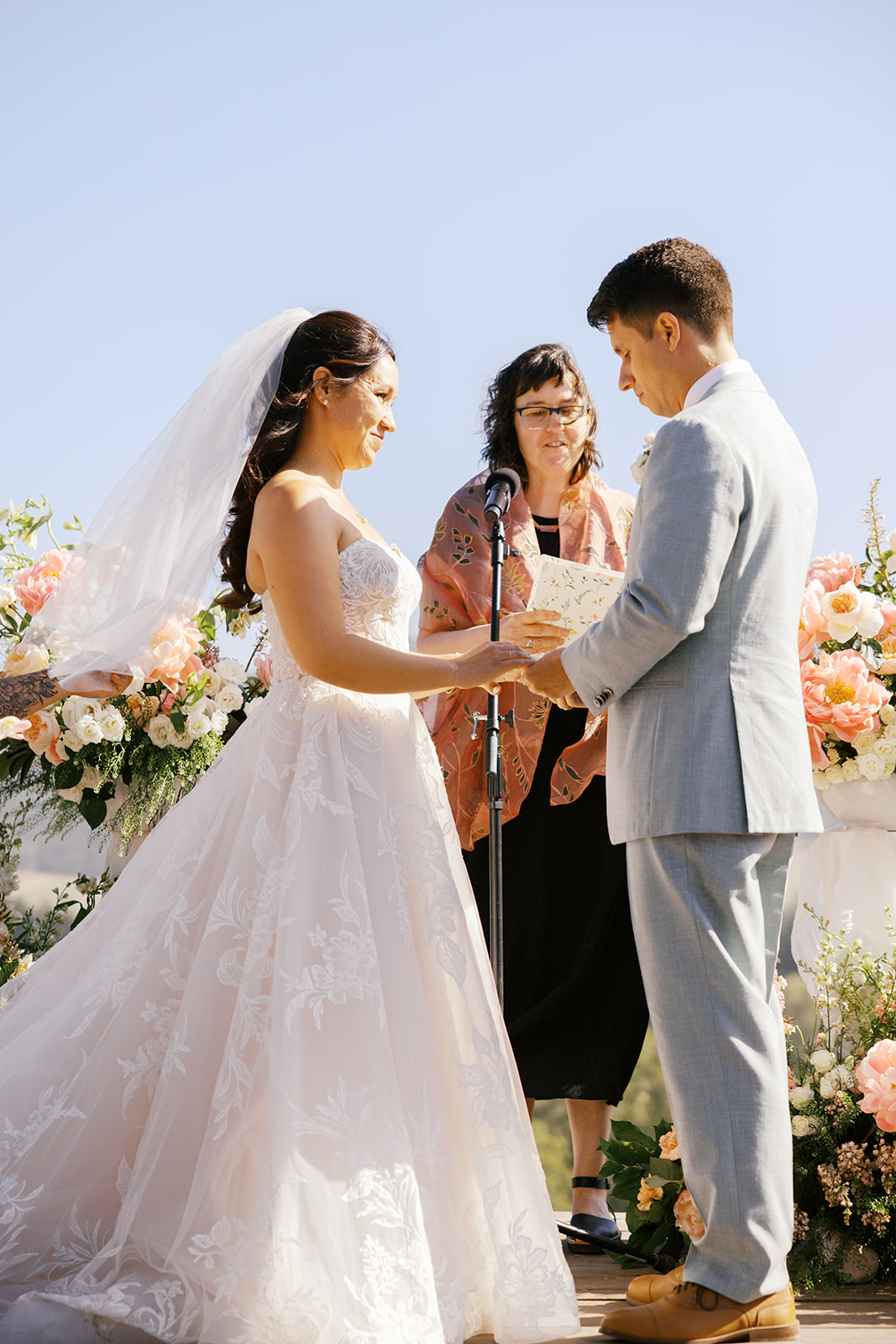 Rachel and Damien exchanging rings at their hillside ceremony