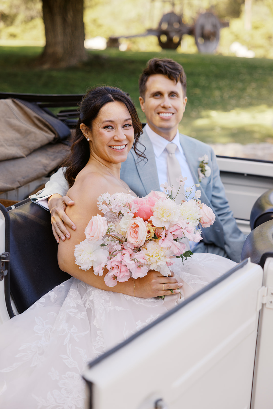 Rachel and Damien seated in the white convertible