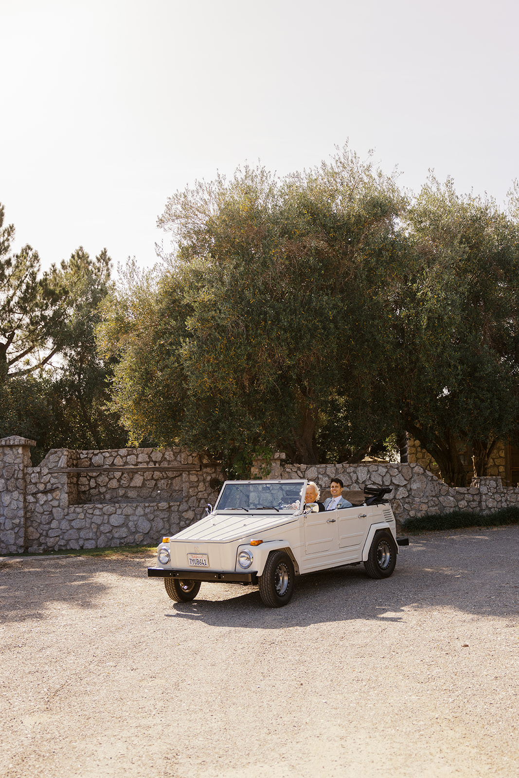 White convertible beside the ranch’s stone walls