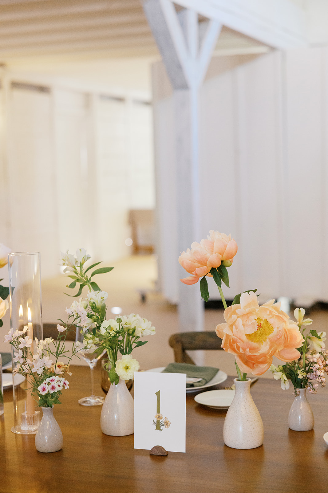 Floral table number among peach flowers and glassware
