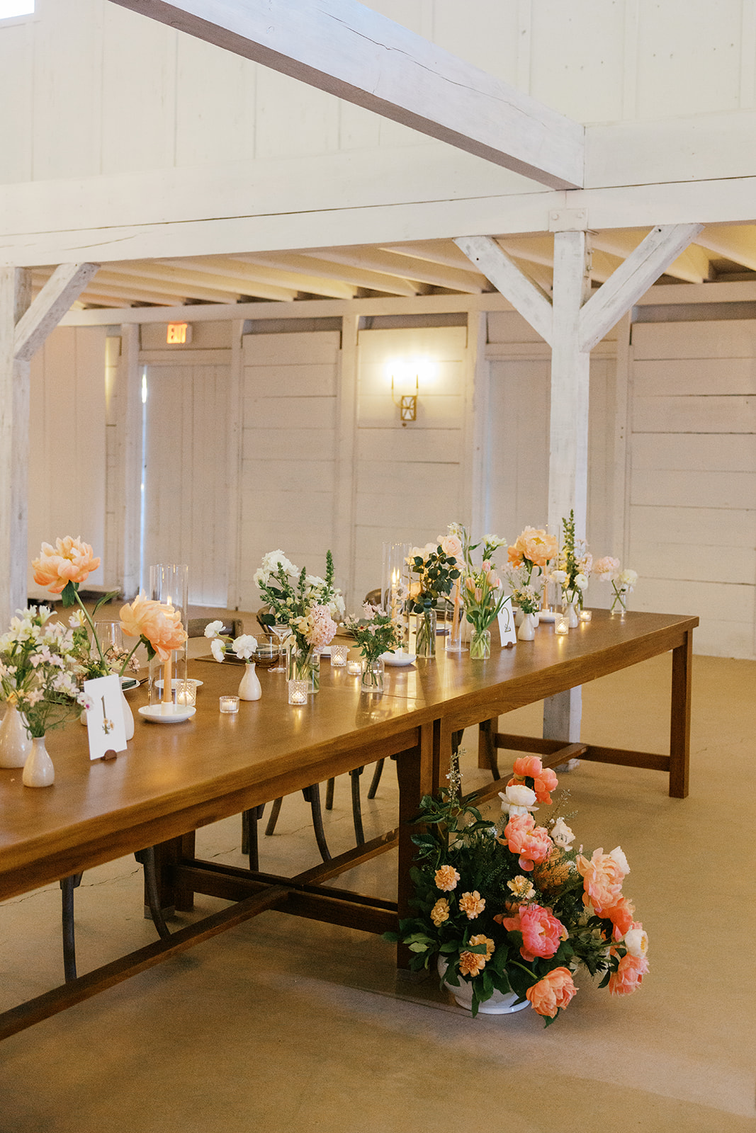 Wood reception table beneath the barn’s white beams