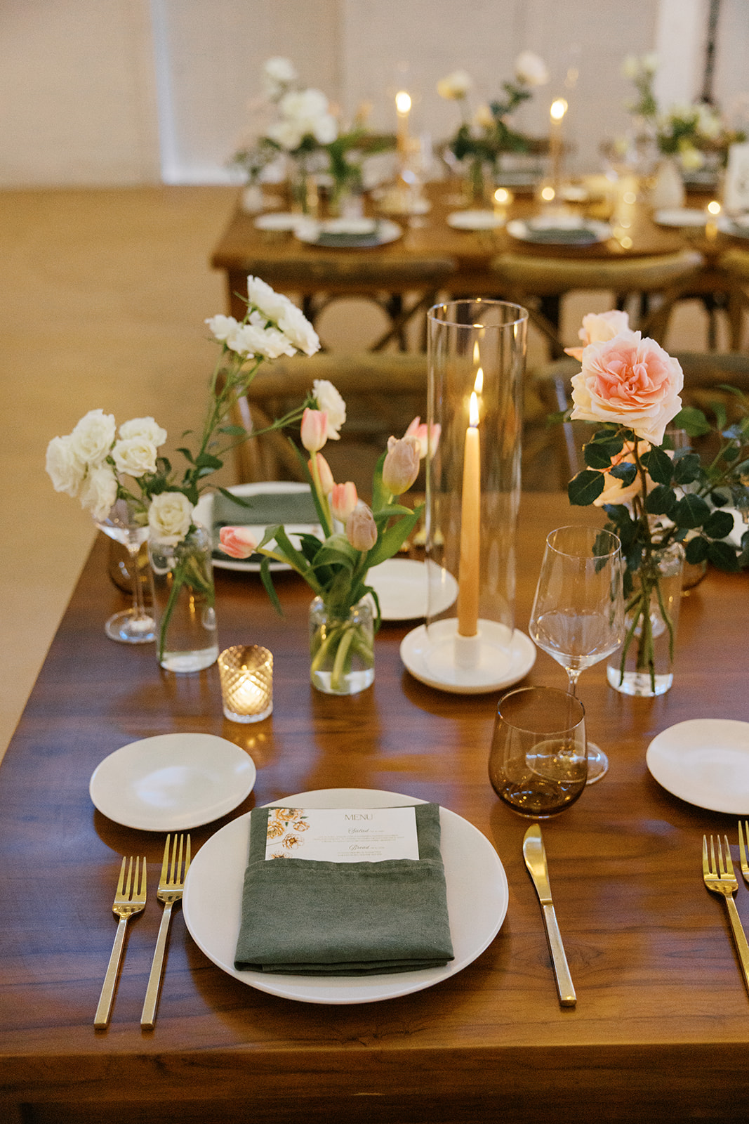 Green linen napkin and gold-toned flatware at a wedding place setting
