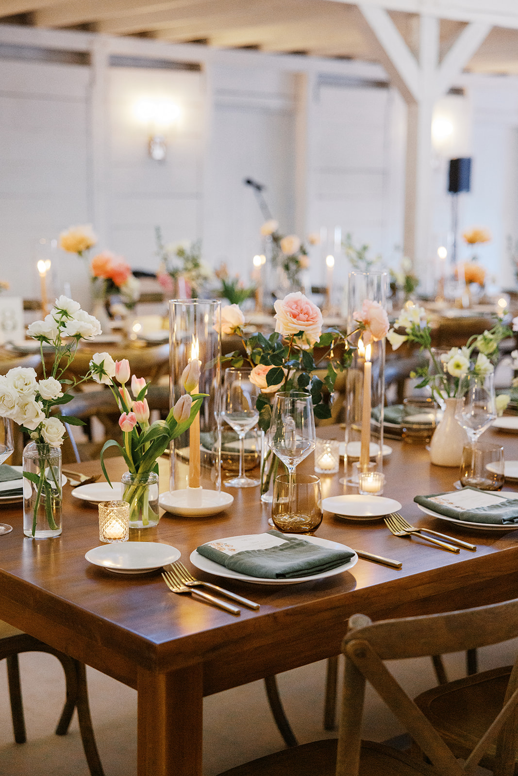 Reception tables with flowers, green napkins, and candlelight