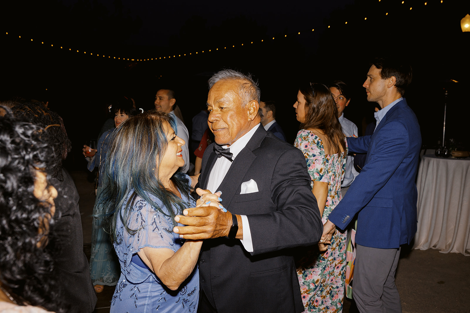 Wedding guests dancing together at the evening reception