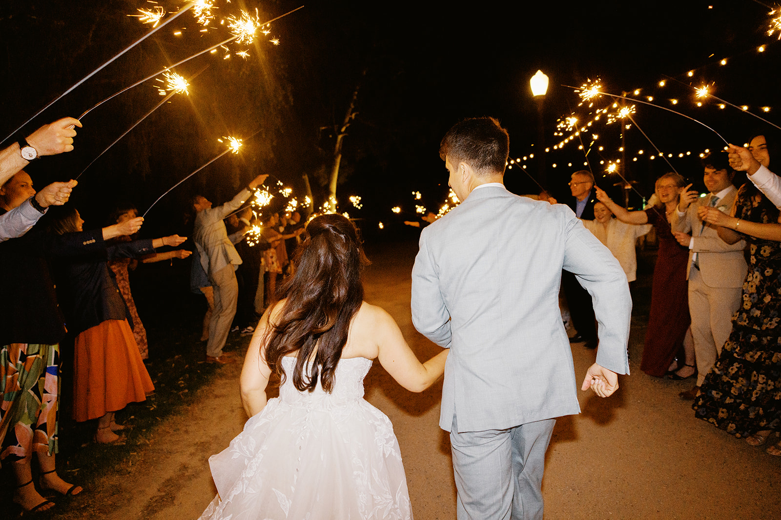 Rachel and Damien walking away through their sparkler farewell