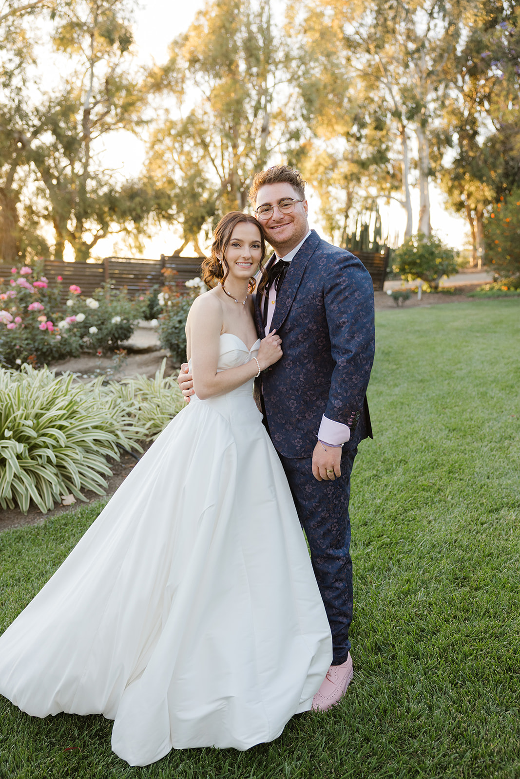 Jordan and Sara embracing on the lawn in evening light