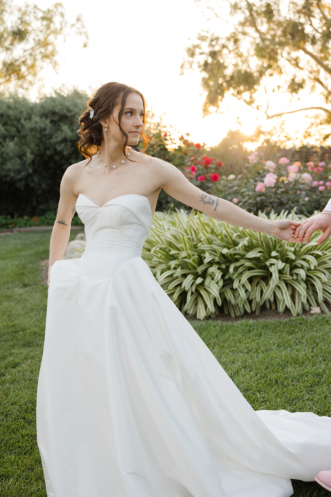 Sara holding Jordan’s hand in the garden at sunset