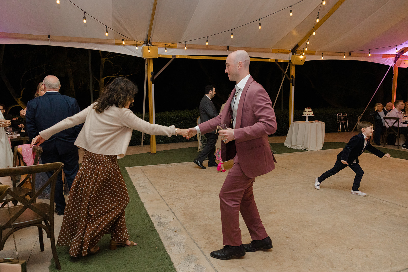 Wedding guests dancing beneath the reception canopy