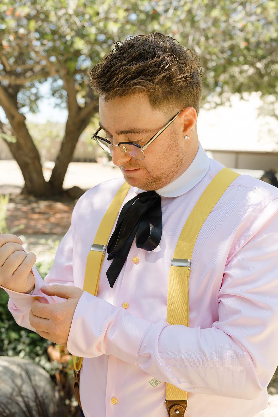 Jordan adjusting his shirt cuffs and yellow suspenders