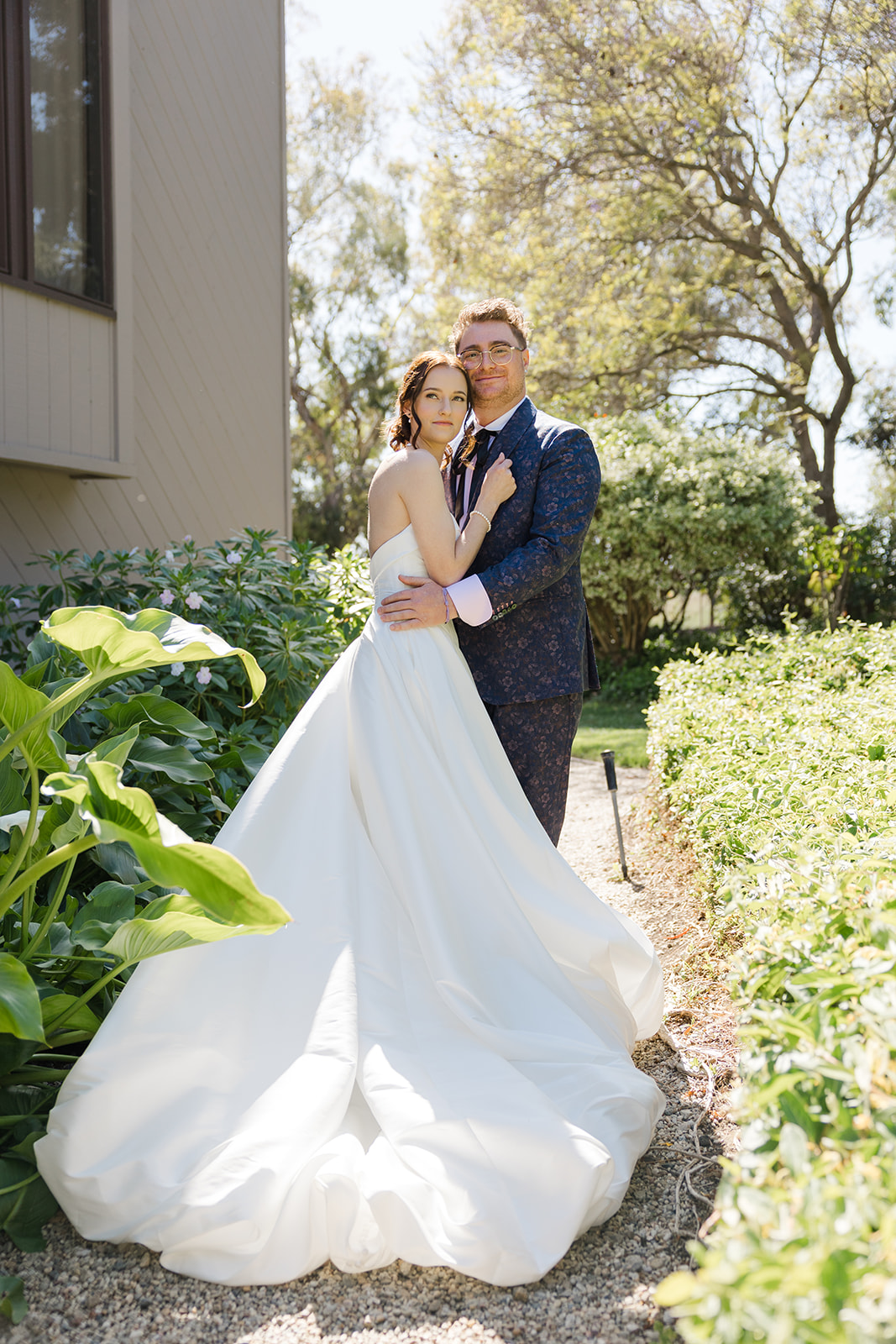 Jordan and Sara posing among lush garden greenery