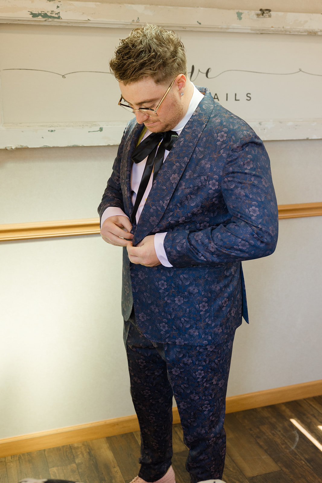 Jordan fastening his floral-patterned suit jacket