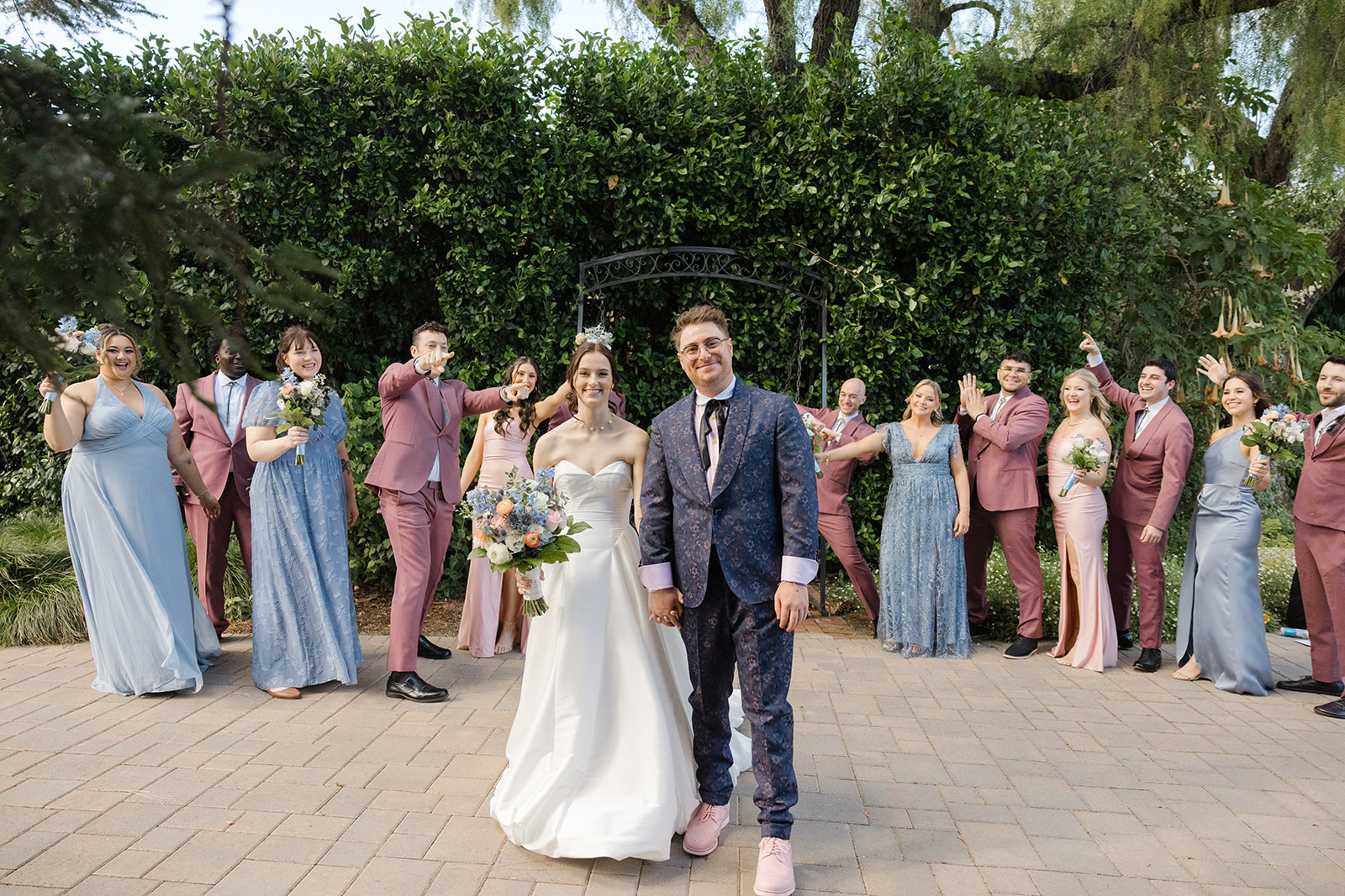 Jordan and Sara walking with their wedding party in the garden