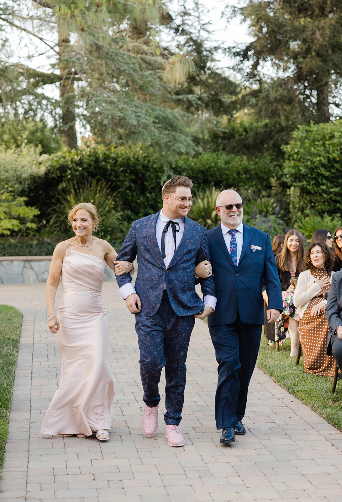 Jordan walking down the garden aisle with his parents