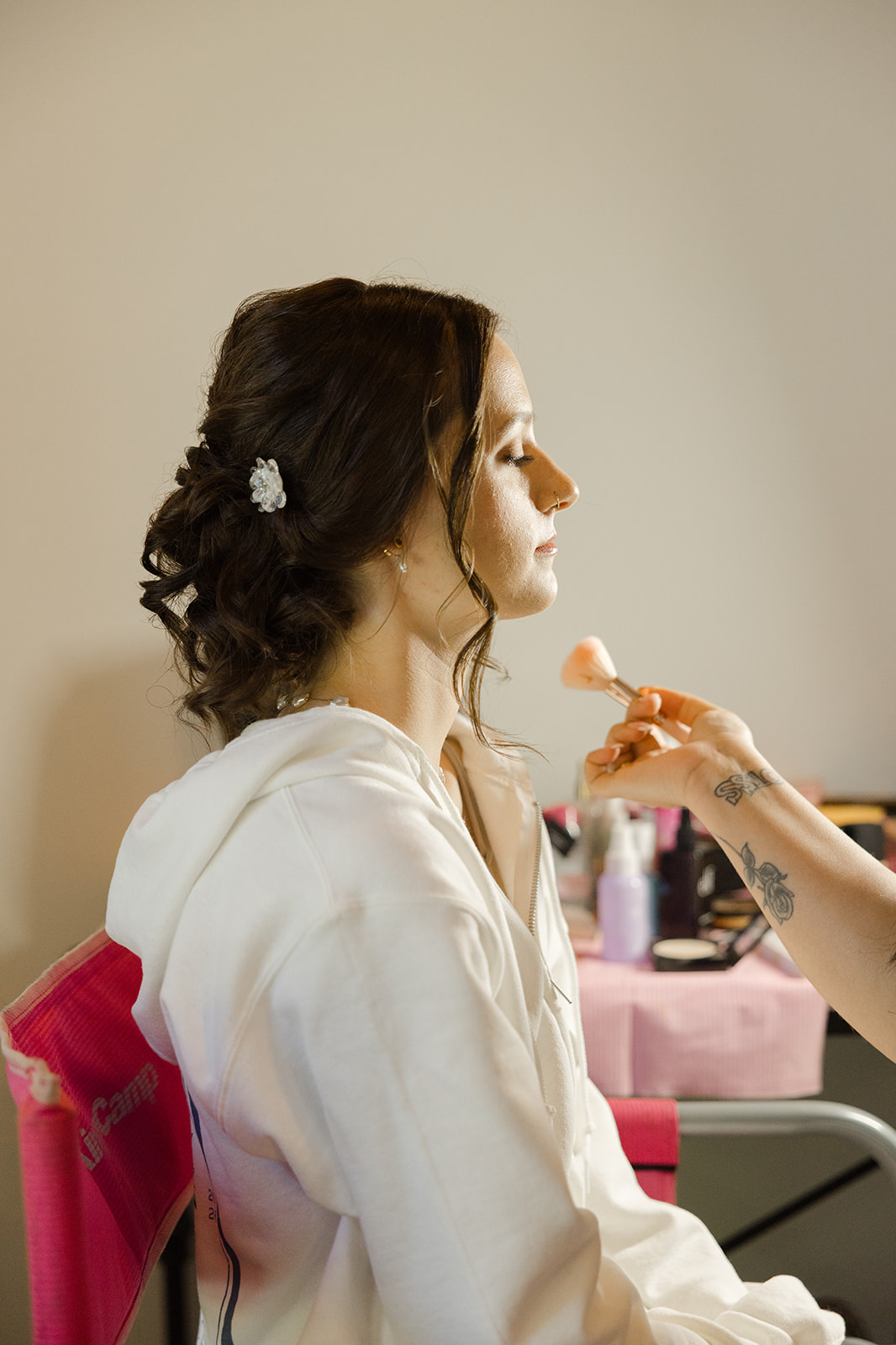 Sara receiving the finishing touches to her wedding makeup