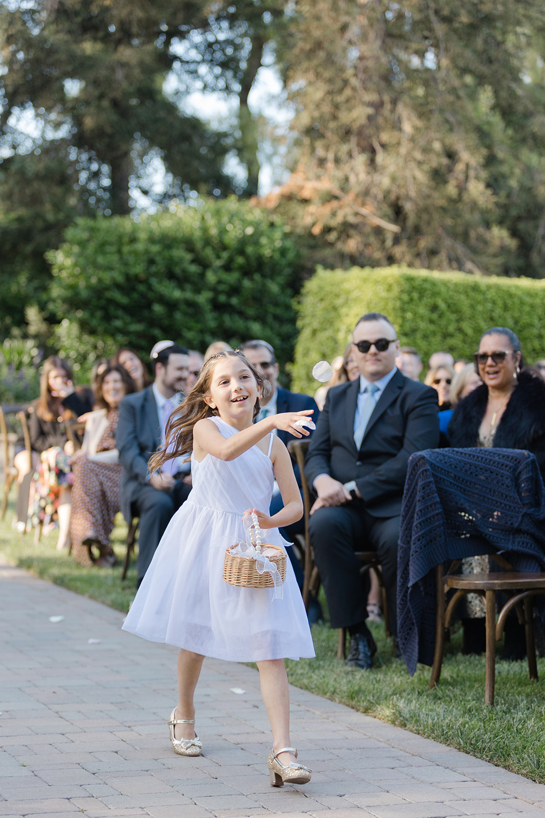 Flower girl scattering petals along the wedding aisle