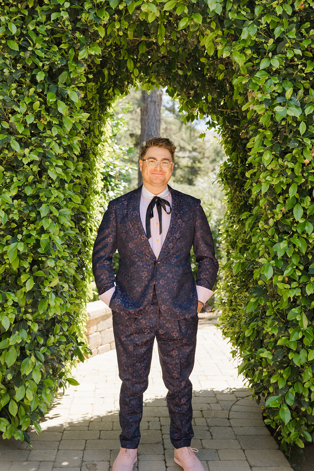 Jordan posing beneath a leafy garden archway
