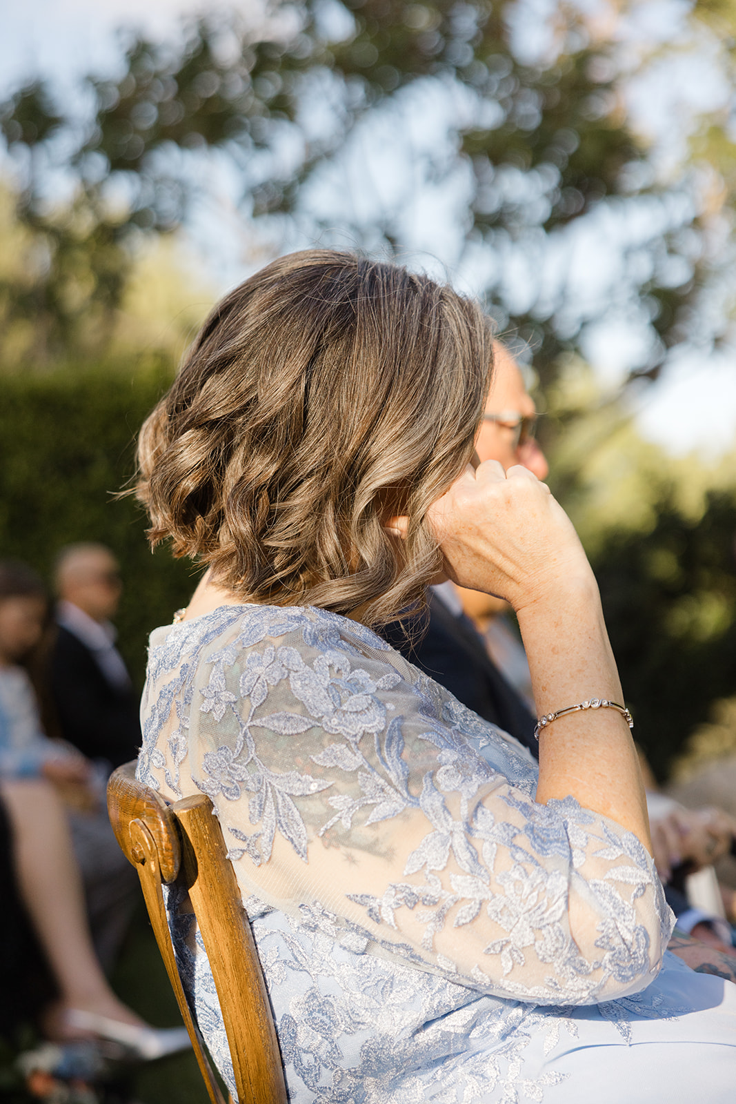 A guest wiping away tears during the garden ceremony