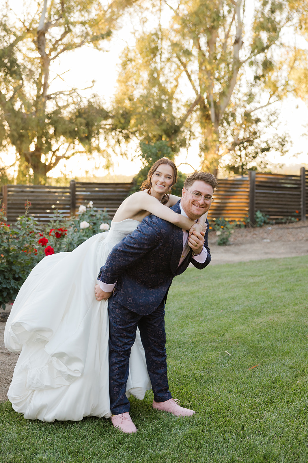 Sara riding on Jordan’s back during playful garden portraits