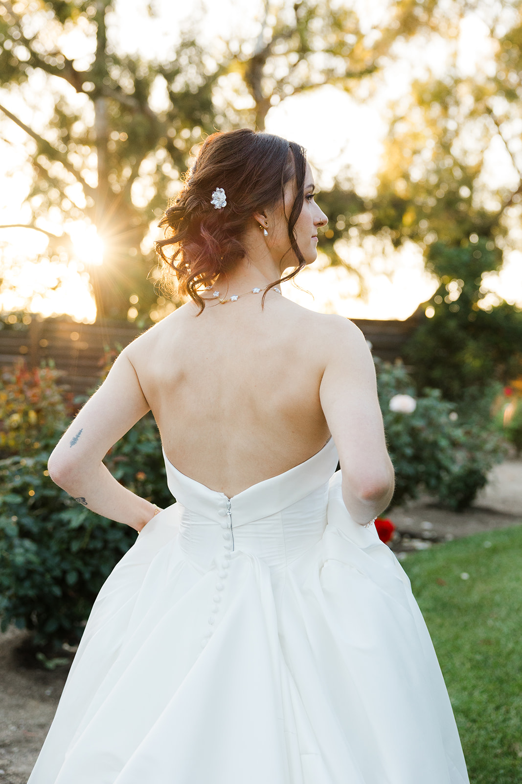Sara’s floral hair accessories and strapless wedding dress at sunset