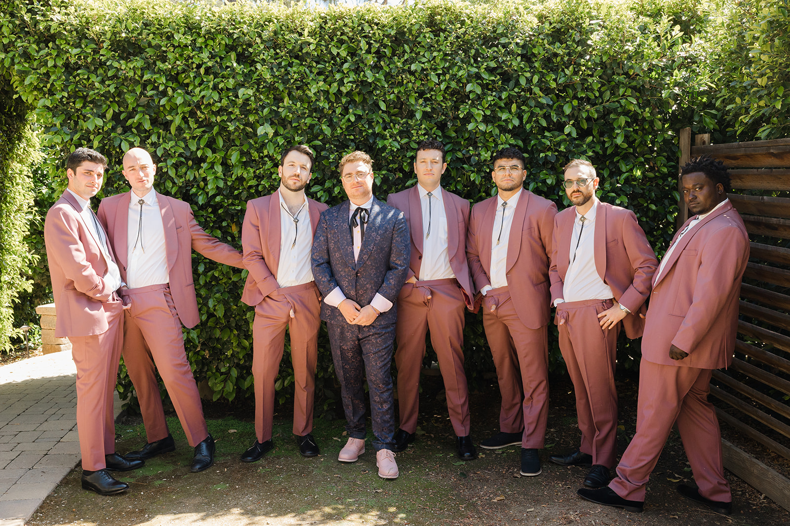 Jordan with his wedding party in rose-colored suits