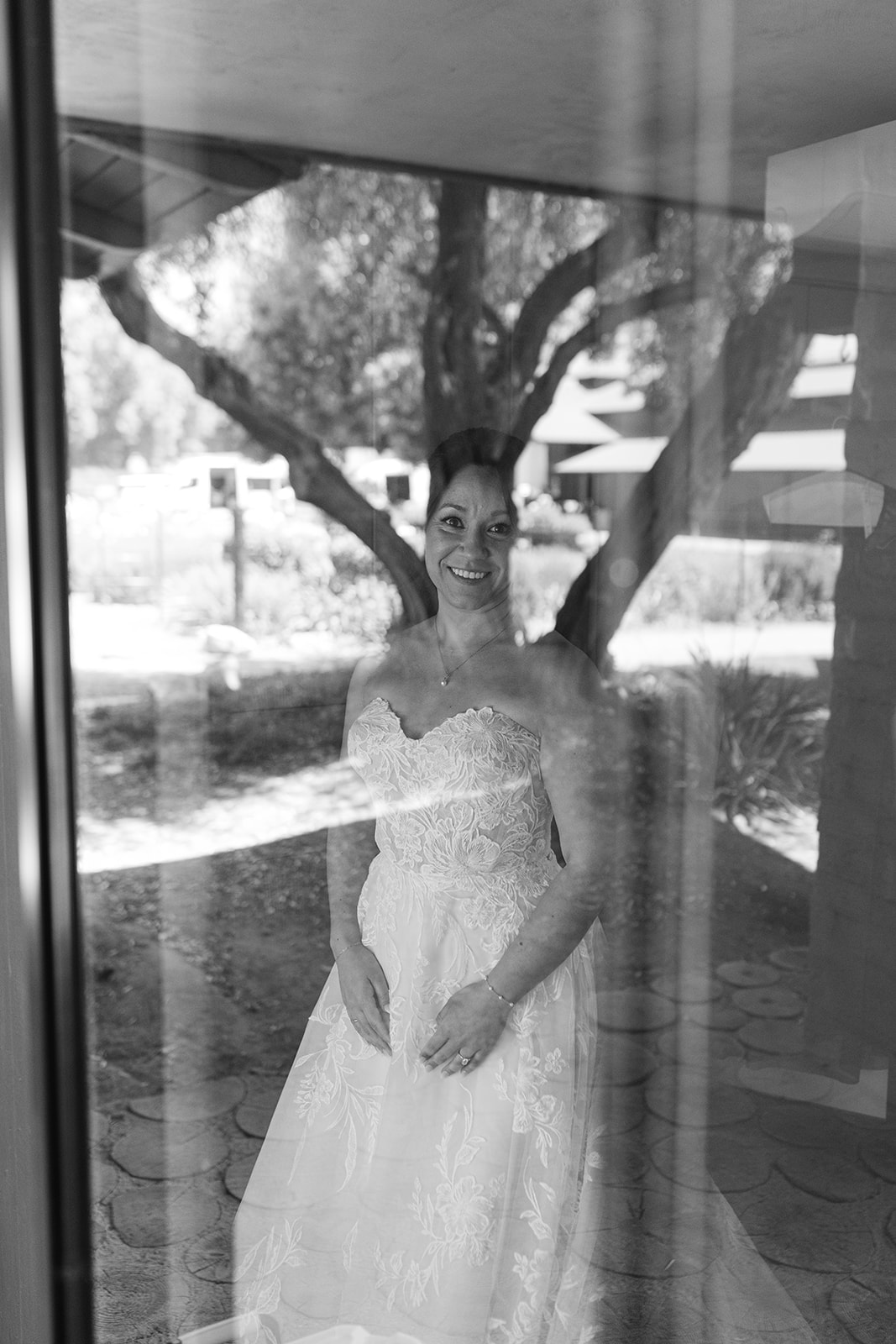 Black-and-white bridal portrait reflected in a window